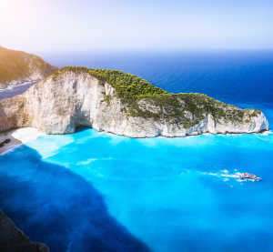 Blick auf den berühmten Navagio-Strand (Schmugglerbucht) auf Zakynthos mit türkisblauem Wasser, weißem Sandstrand und steilen Klippen.