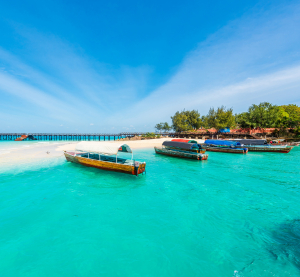 Boote auf türkisblauem Wasser vor der Küste von Sansibar.