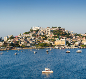 Blick auf Acapulco mit vielen Booten im Wasser und Häusern am Hang.