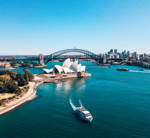 Luftaufnahme des Sydney Opera House und der Sydney Harbour Bridge mit Schiffen im Hafen.