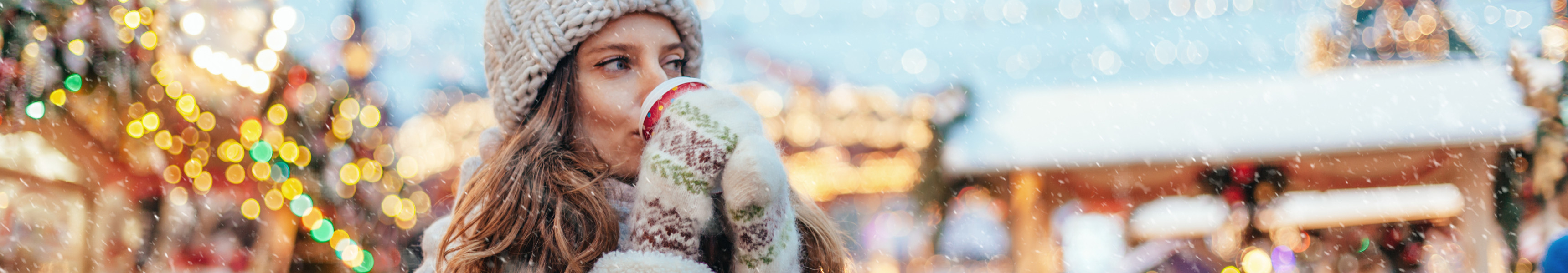 Frau trinkt Glühwein auf Weihnachtsmarkt