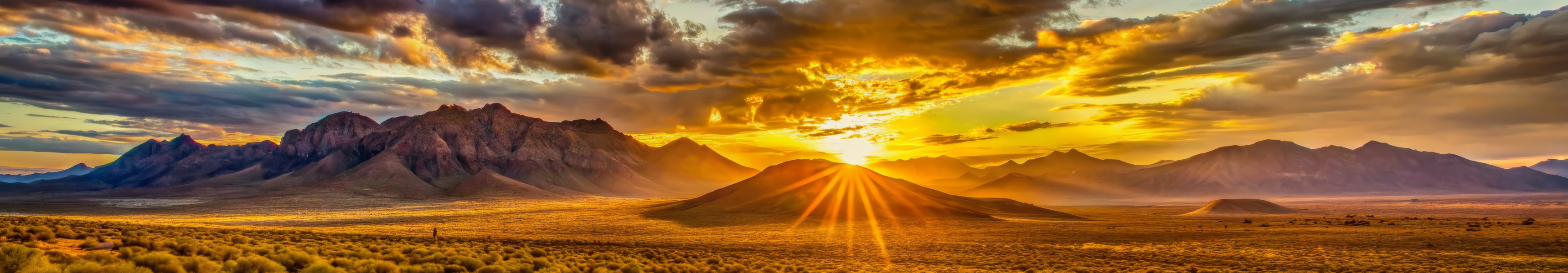 Majestätische Bergsonnenuntergangslandschaft mit goldenen Wolken und Sonnenstrahlen
