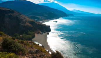 Blick auf die Küste von Kreta mit Bergen und tiefblauem Meer.