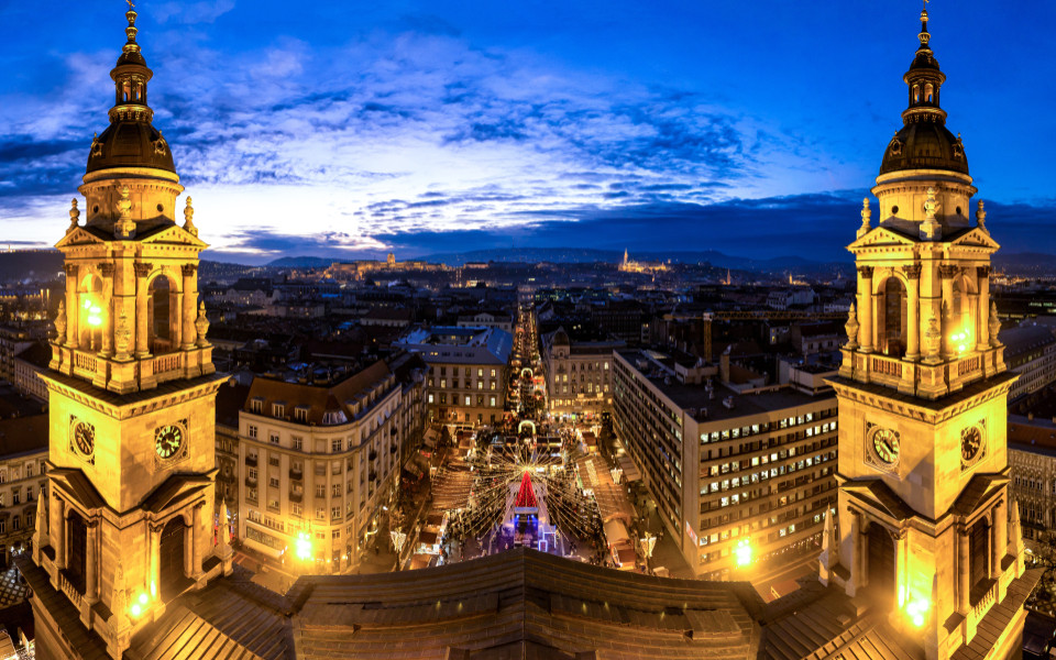 Weihnachtsmarkt in Budapest vor der St.-Stephans-Basilika, mit funkelnden Lichtern, festlicher Stimmung und einem beeindruckenden Blick über die Stadt in der Abenddämmerung.
