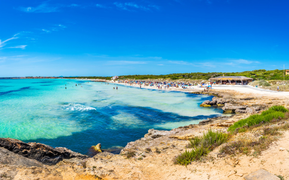Mallorca Geheimtipp: Strand Playa Es Trenc auf Mallorca mit kristallklarem Wasser, feinem Sand und unberührter Natur unter strahlend blauem Himmel.