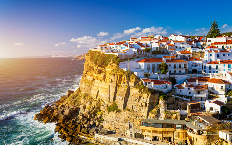 Malerisches Küstendorf Azenhas do Mar nahe Sintra, mit weißen Häusern auf steilen Klippen, spektakulärem Blick auf den Atlantik und goldenem Sonnenlicht.