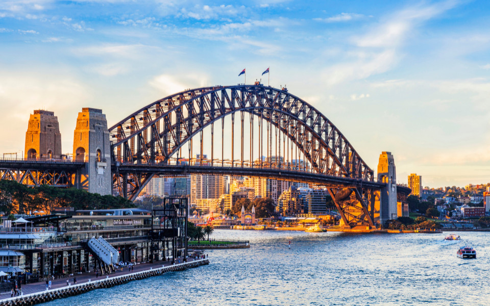 Sydney Harbour Bridge bei Tageslicht mit Blick auf den Hafen und umliegende Gebäude.