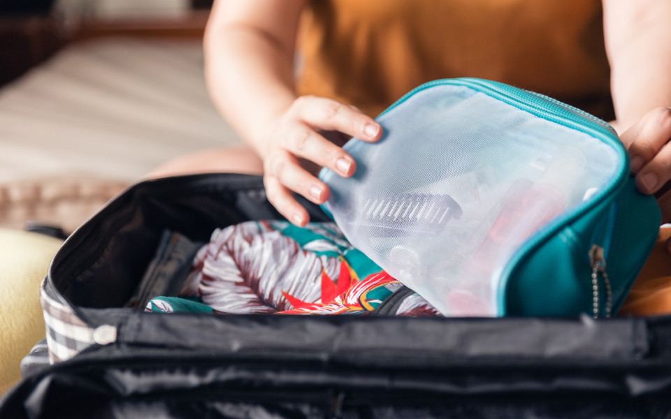 Frau verpackt Ihre Kleidung in unterschiedliche Beutel für den Urlaub 