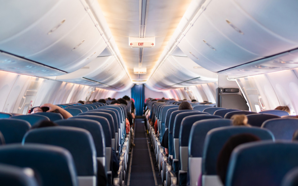 Ansicht eines Flugzeuges von innen mit leeren und schon besetzen Plätzen