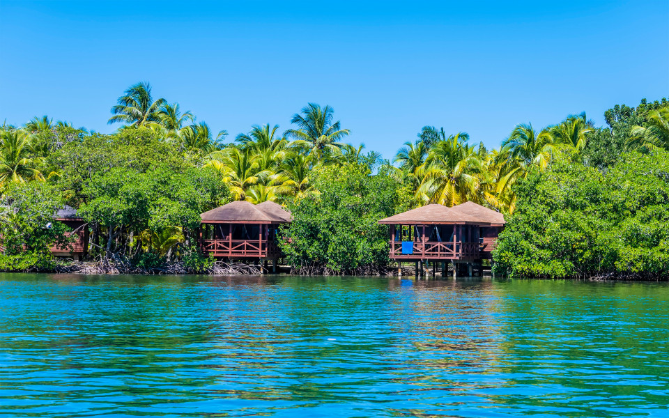 Ein Blick auf Strandhütten in der Nähe von West Bay auf der Insel Roatan an einem sonnigen Tag