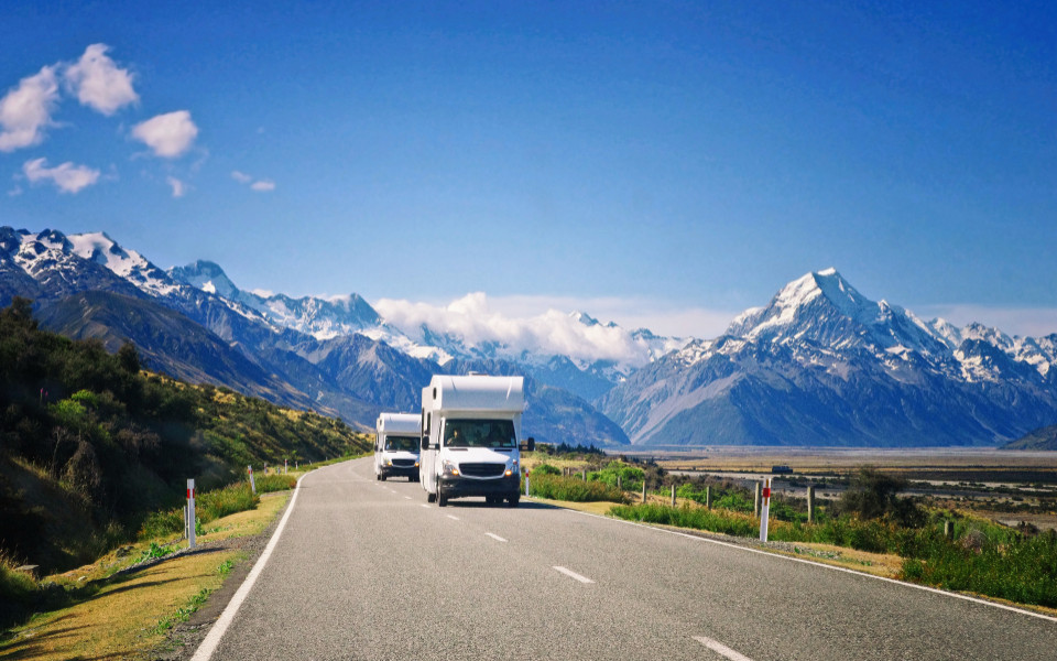 Zwei weiße Wohnwagen unterwegs in Neuseeland. 