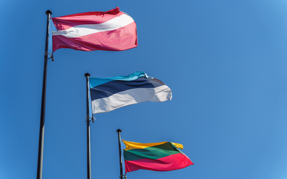 Die Flaggen der drei baltischen Länder Litauen, Lettland und Estland flattern vor einem strahlend blauen Himmel