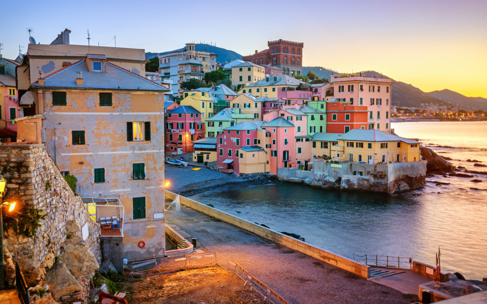Bunte Häuser am Meer im Stadtviertel Boccadasse in Genua bei Sonnenuntergang.
