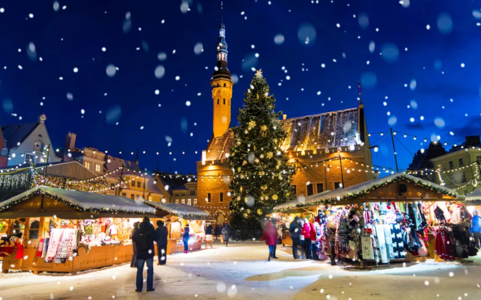 Blick auf den Weihnachtsmarkt in Tallinn mit Beleuchtung der Kirche 