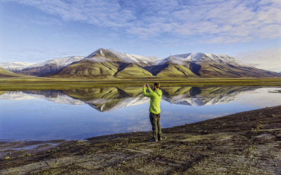 Mann steht am Longyearbyen_Svalbard und macht ein Foto